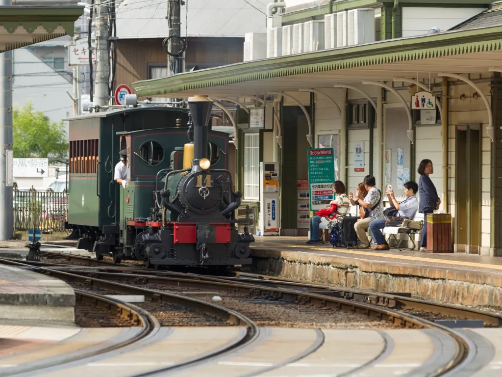 坊っちゃん列車と駅で待つ乗客の画像