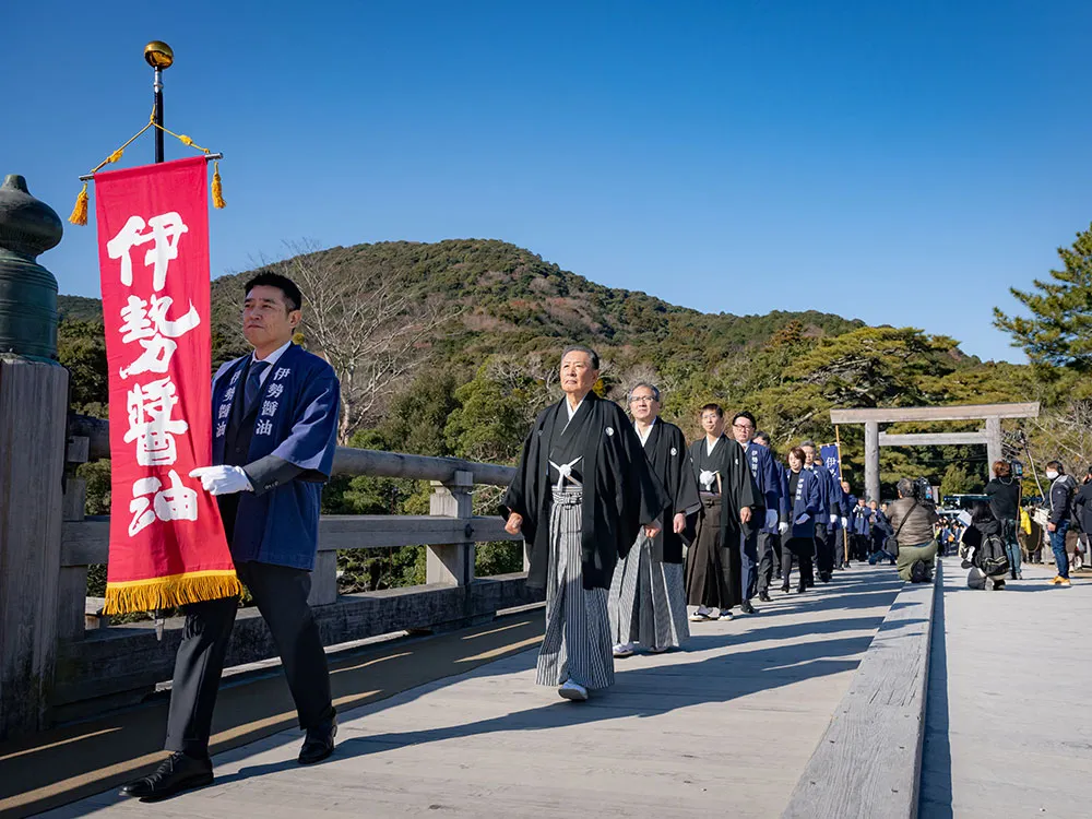 伊勢神宮奉納時に正装で橋を渡る関係者の画像