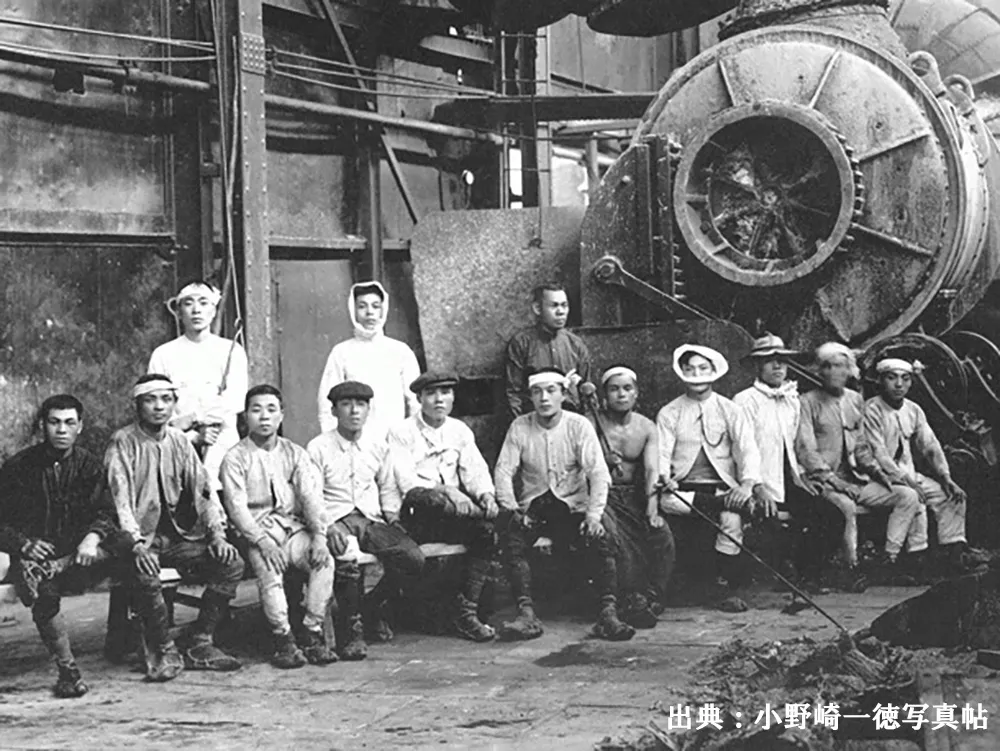 製錬所で最新のベッセマ-転炉を背景に撮影された近代化を担った製錬夫たちの画像