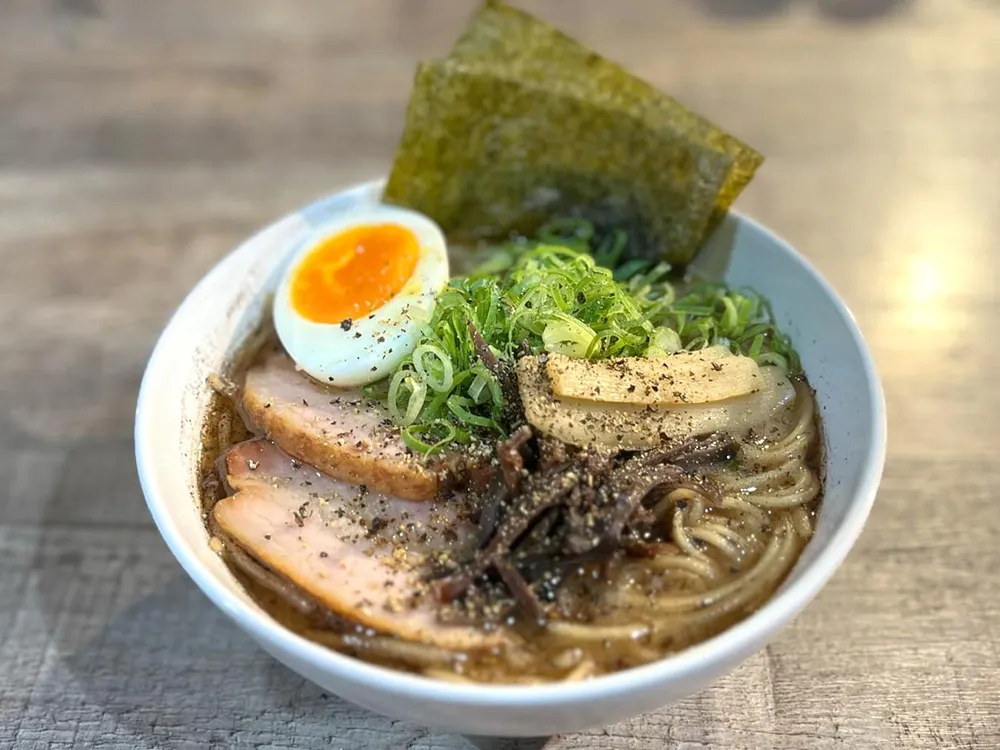チャーシュー、キクラゲ、ネギ、半熟卵などをのせて作った熊本ラーメンの画像