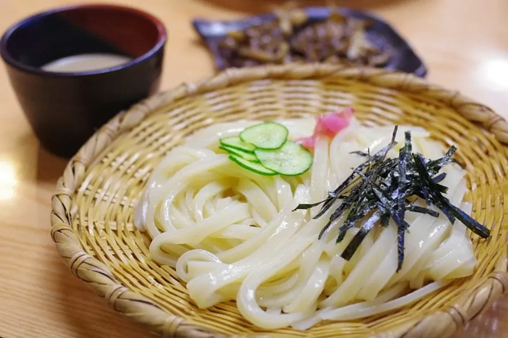 ざるに盛られきゅうりと海苔がのった水沢うどんの画像