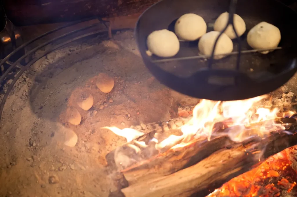 囲炉裏で灰焼きおやきを作る画像