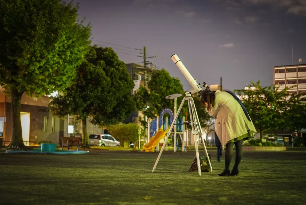 公園で天体観測をする人の画像