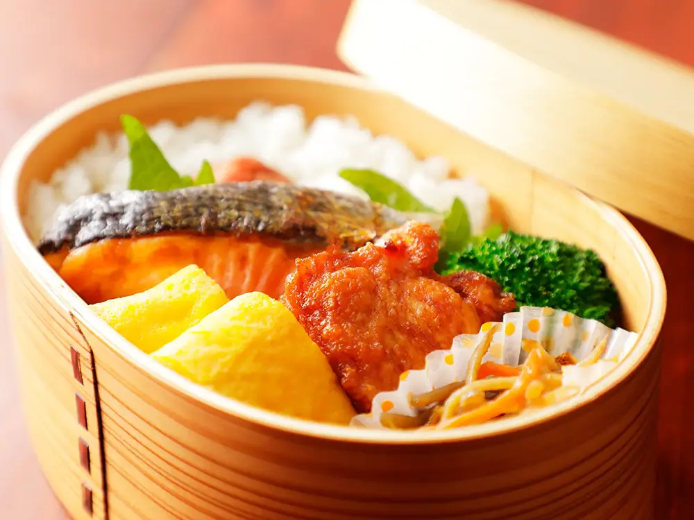 わっぱに入った美味しそうなお弁当の画像