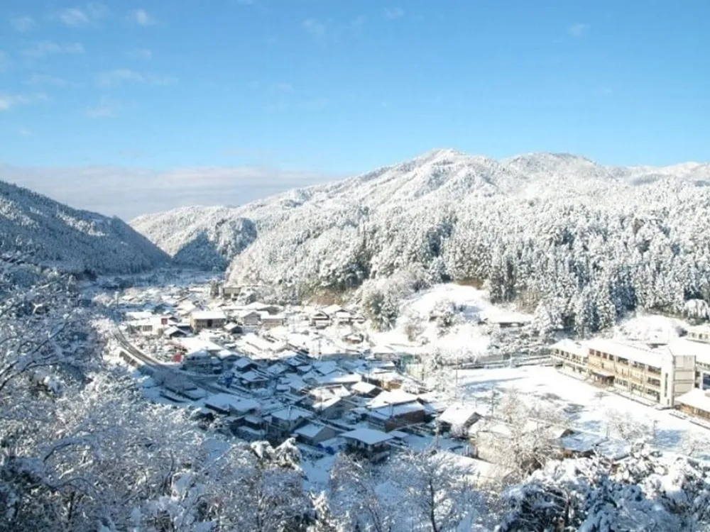 雪に覆われた東白川村を山頂から見下ろした画像