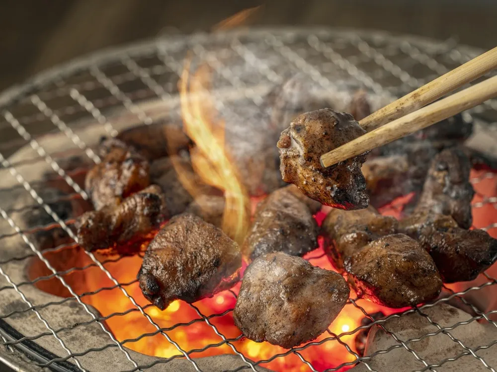 鶏の炭火焼を七輪で焼いている画像