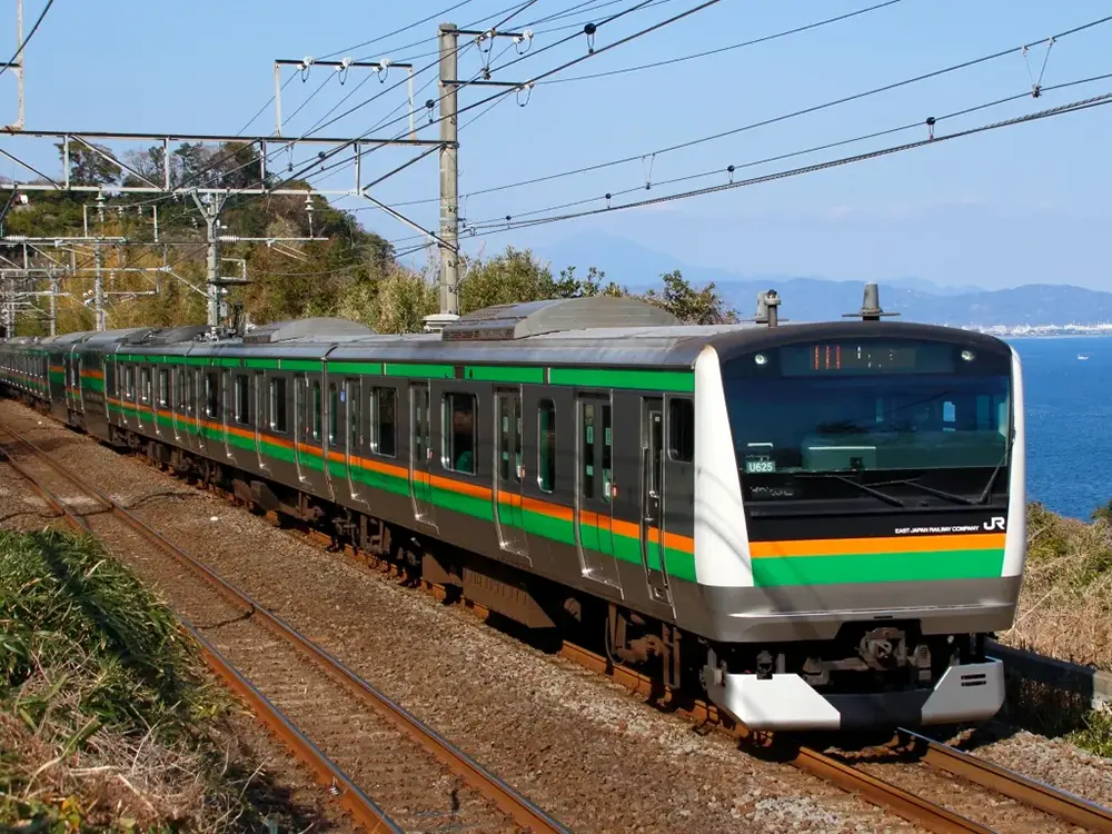 海沿いを行く東海道線普通列車の画像