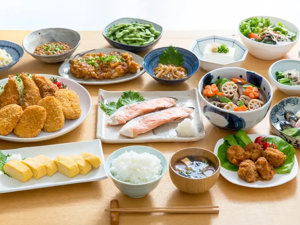 たくさんの家庭料理がテーブルの上に並ぶ画像