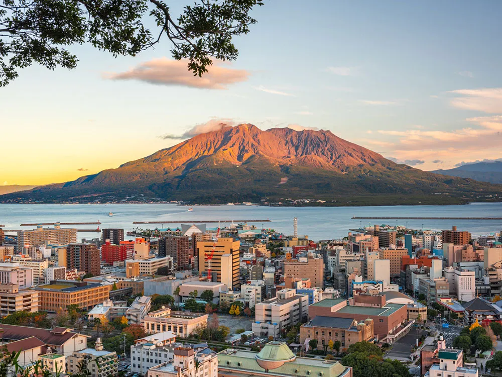 夕暮れ時、桜島火山と鹿児島の街並みの画像