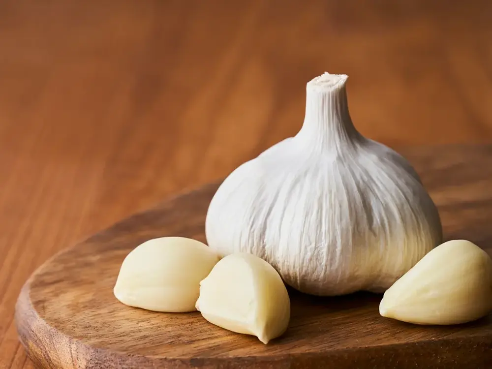 カッティングボードに乗ったにんにくの画像