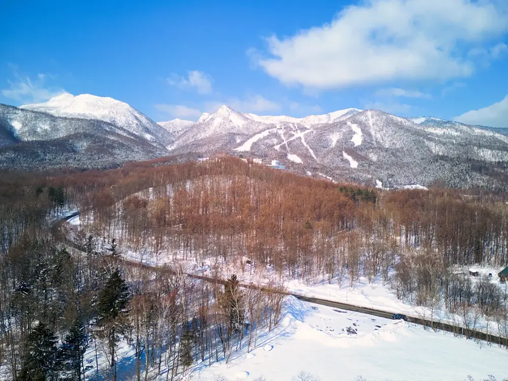 北海道札幌市の冬季の雪山と道路の空中画像