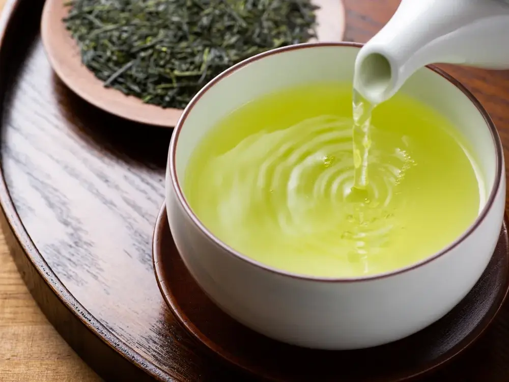 急須から緑茶を茶碗に注いでいる画像