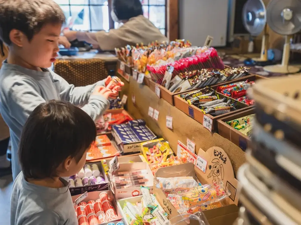 駄菓子屋で子どもが品物を選んでいる画像