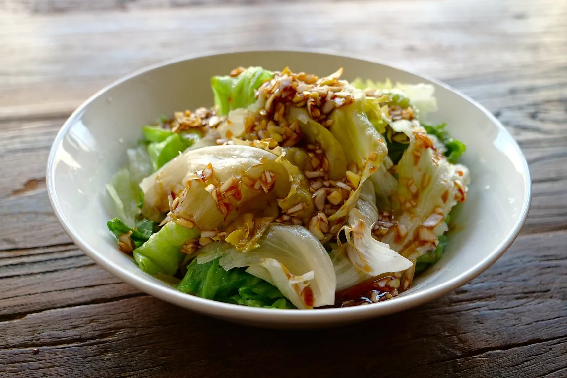 春レタス丸ごとボイルのオイスターたれを白い皿に盛り付けた画像