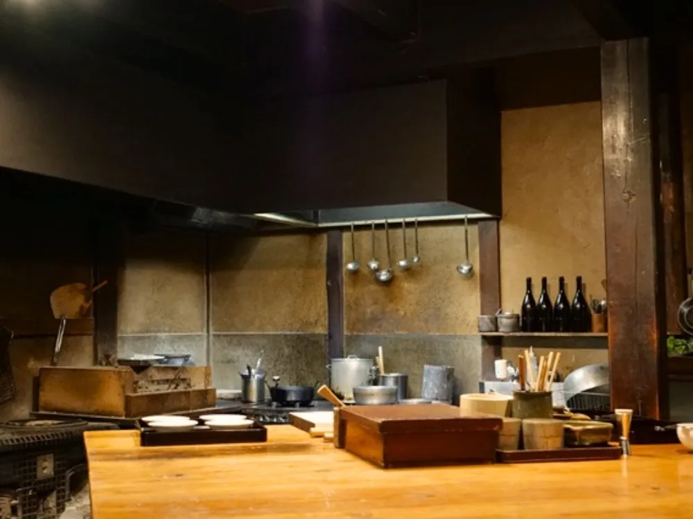 調理台越しにキッチンと調理道具が見える写真