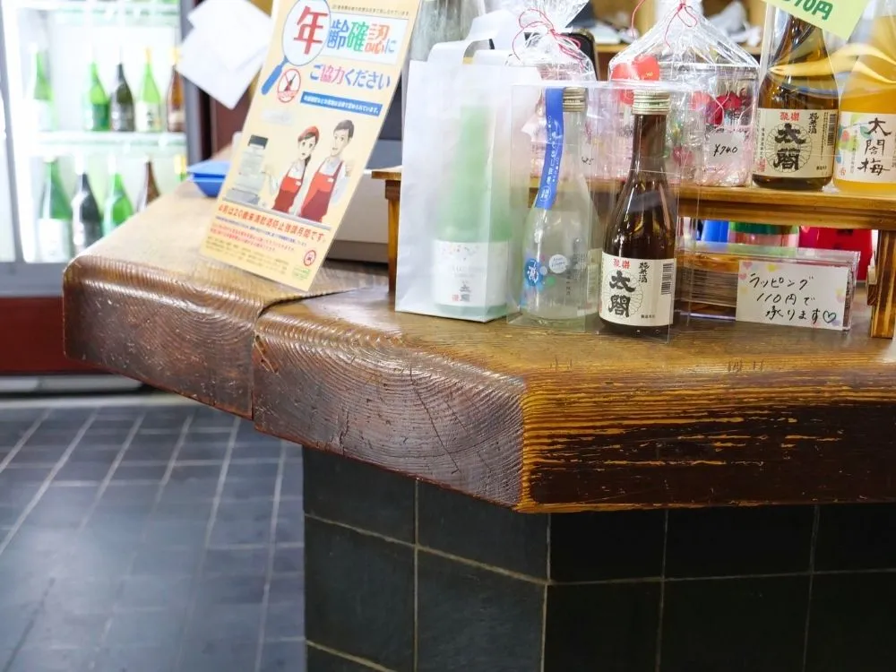 かつて角打ちとして使われていた木のカウンターの画像