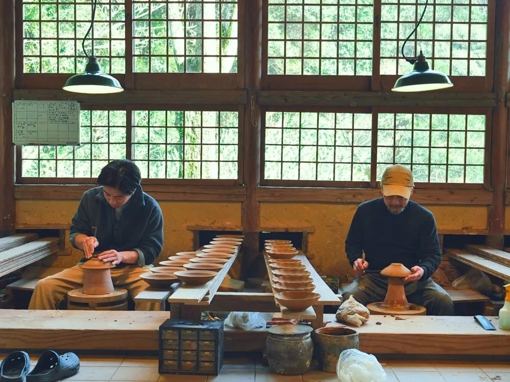 ろくろ場で器と向き合う中里健太さんと中里太亀さんの写真