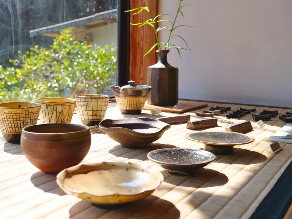 窓際に設けられた畳敷きの展示スペースの上に並べられた器の画像