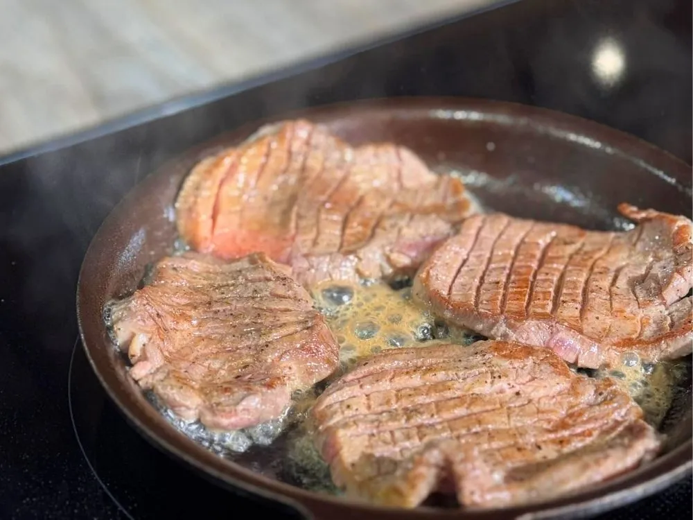 鉄フライパンで牛タンを焼いている画像