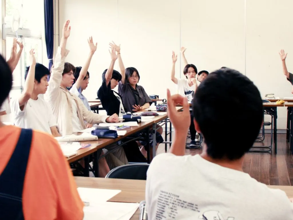 全体会で、生徒や教員たちが議題について多数決を行っている様子の写真
