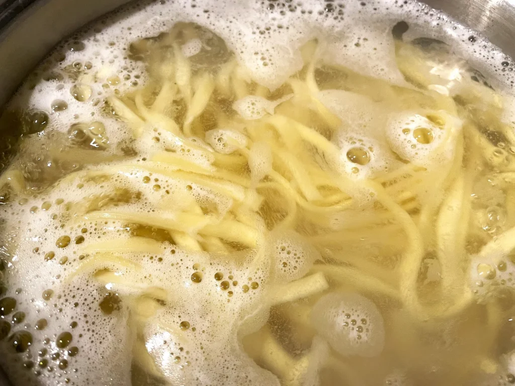 パスタを鍋で茹でているイメージ画像
