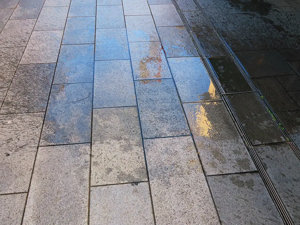  歩道に打ち水がされている画像
