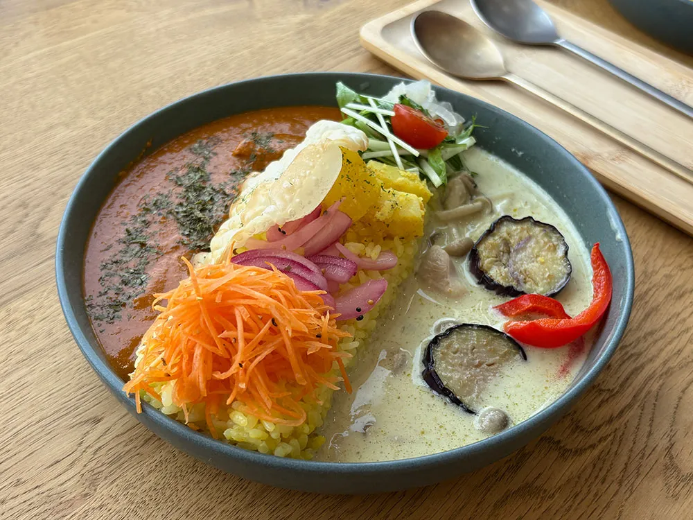カレーの2種盛りとカトラリーの画像
