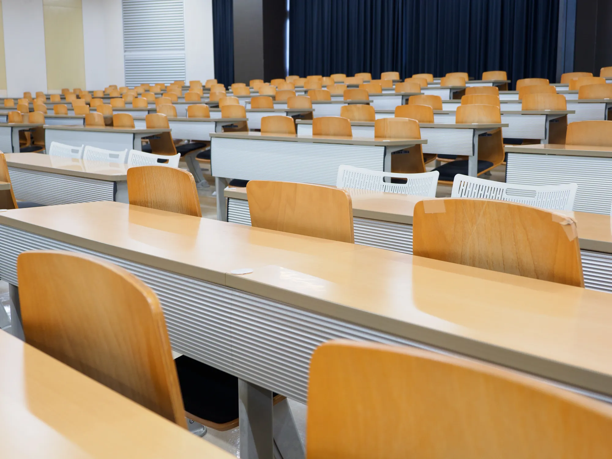 学校の明るい教室内に机と椅子が並ぶ画像