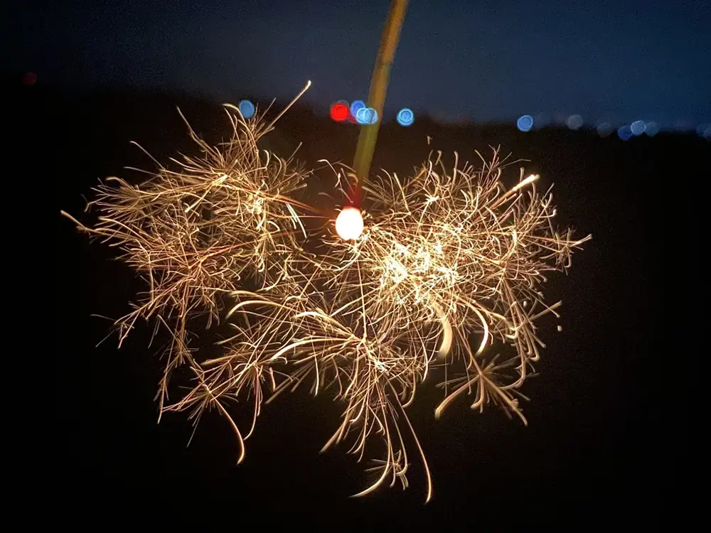 線香花火に火をつけて火花がはじけている画像