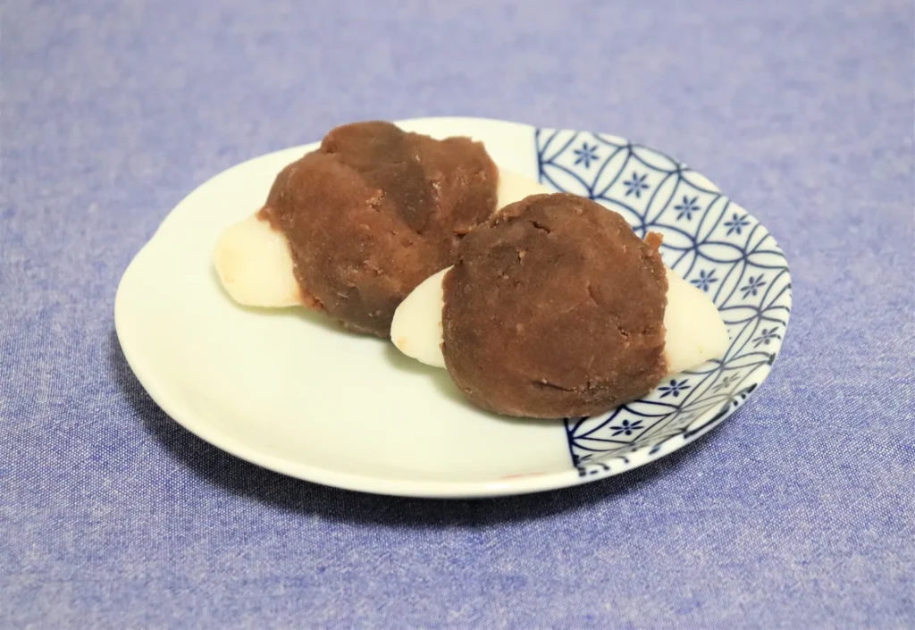 サトイモを模した楕円の団子に帯状の小豆餡を巻いた団子の画像
