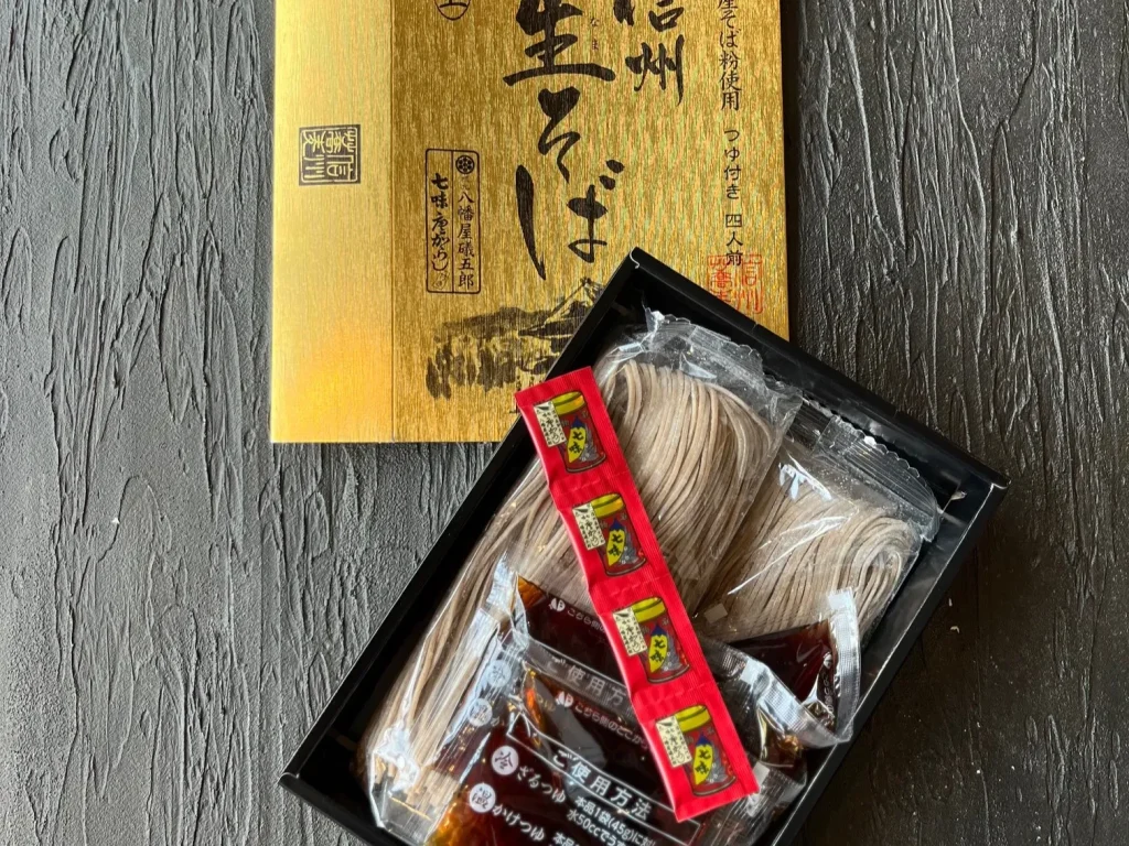 信州生そばの開封後、中の半生麺とつゆ、七味唐辛子の画像